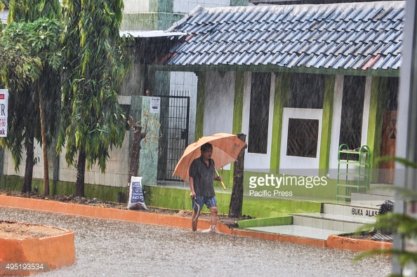 MAKASSAR, SOUTH SULAWESI, INDONESIA - 2015/10/31: A man walks under an umbrella through the rain in Kapasa. Heavy rain hits the city after four dry months. (Photo by Yermia Riezky Santiag/Pacific Press/LightRocket via Getty Images)